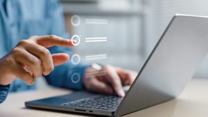 Mani su un computer portatile mentre compilano un modulo digitale