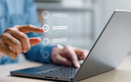 Mani su un computer portatile mentre compilano un modulo digitale
