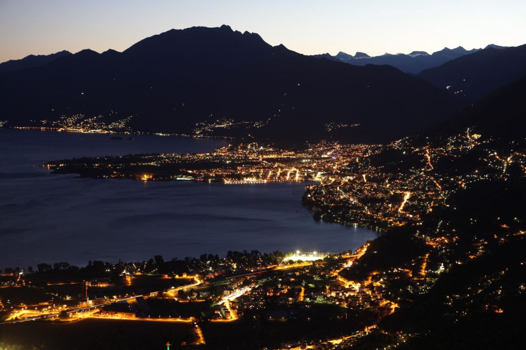 Locarno e il Lago Maggiore illuminati di sera, visti dalla montagna